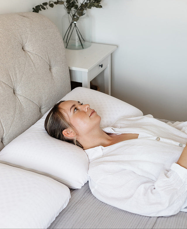 woman sleeping on natural latex pillow on bed
